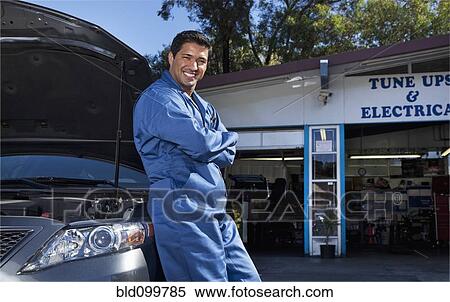 Stock Photography - Middle Eastern mechanic leaning on car. Fotosearch
