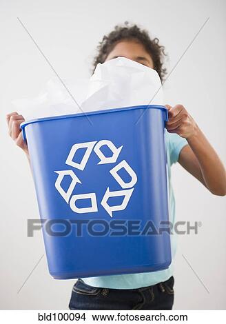 Picture - Mixed race girl carrying recycling bin. Fotosearch