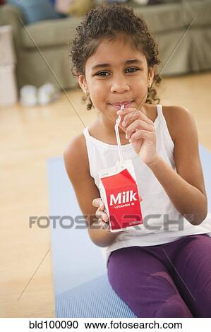 Stock Image - Mixed race girl drinking milk. Fotosearch