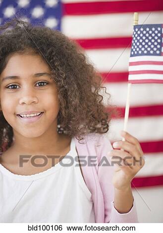 Stock Photograph - Mixed race girl holding American flag. Fotosearch