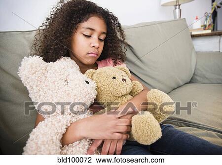 Mixed race girl sitting on sofa with teddy bear View Large Photo Image Stock Image - Mixed race girl sitting on sofa with teddy bear. Fotosearch