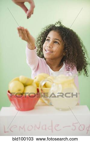Stock Image - Mixed race girl with lemonade stand. Fotosearch