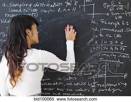 Stock Photography - Pacific Islander teacher erasing math from blackboard. Fotosearch