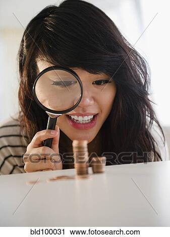Pacific Islander woman examining pennies with magnifying glass View Large Photo Image Stock Image - Pacific Islander woman examining pennies with magnifying glass. Fotosearch