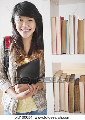 Picture - Pacific Islander woman holding digital tablet. Fotosearch