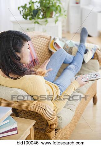 Pacific Islander woman laying on sofa watching television View Large Photo Image Stock Photograph - Pacific Islander woman laying on sofa watching television. Fotosearch