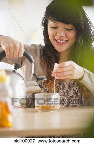 Stock Photo - Pacific Islander woman making hot tea. Fotosearch