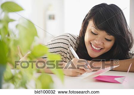 Stock Image - Pacific Islander woman writing on greeting card. Fotosearch