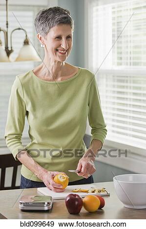 Senior woman cutting fruit View Large Photo Image Stock Photo - Senior woman cutting fruit. Fotosearch