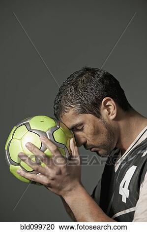 Serious athlete holding soccer ball View Large Photo Image Stock Image - Serious athlete holding soccer ball. Fotosearch