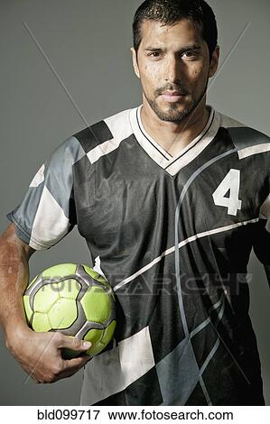 Serious athlete holding soccer ball View Large Photo Image Stock Photo - Serious athlete holding soccer ball. Fotosearch