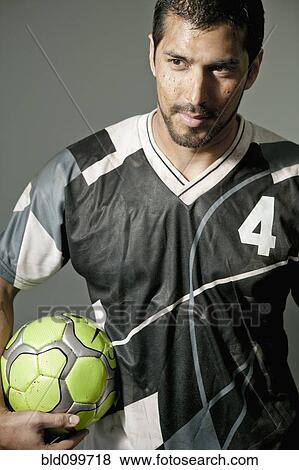 Stock Photo - Serious athlete holding soccer ball. Fotosearch