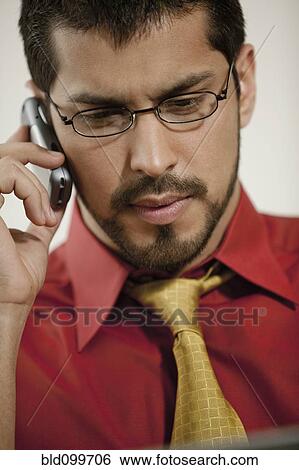 Stock Photograph - Serious businessman talking on cell phone. Fotosearch