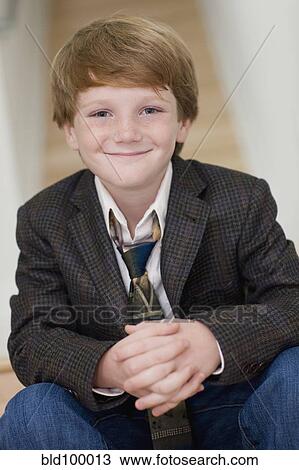 Stock Image - Smiling Caucasian boy in suit. Fotosearch