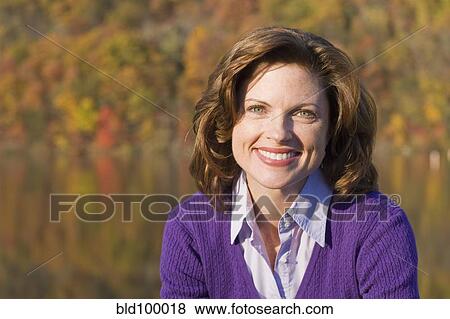 Smiling Caucasian woman outdoors in autumn View Large Photo Image Stock Photo - Smiling Caucasian woman outdoors in autumn. Fotosearch