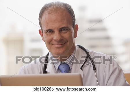 Stock Photography - Smiling Chilean doctor with laptop. Fotosearch