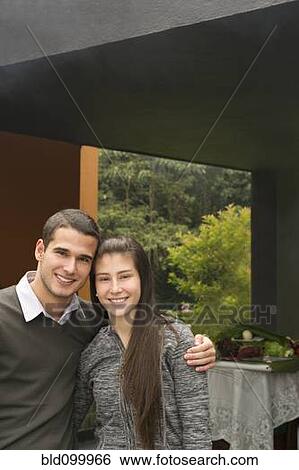 Stock Photograph - Smiling Hispanic couple hugging. Fotosearch