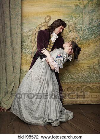 Stock Image - Actors in old-fashioned costumes hugging on stage. Fotosearch
