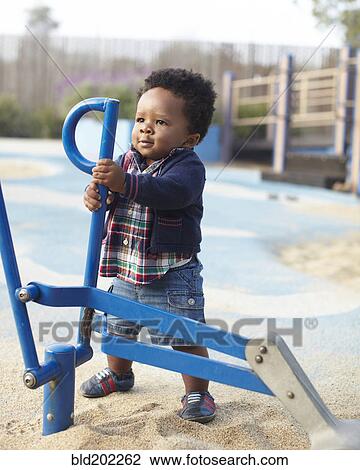 Stock Image - African American baby playing in park. Fotosearch