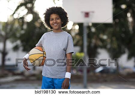 Stock Image - African American boy holding basketball. Fotosearch