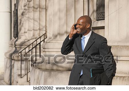 Stock Image - African American businessman talking on cell phone. Fotosearch