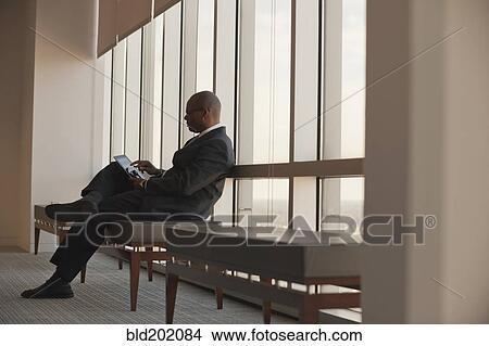 Picture - African American businessman using digital tablet. Fotosearch