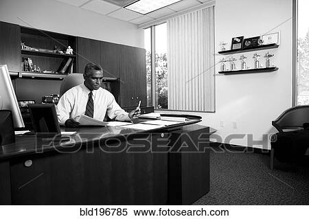 Stock Photography - African American businessman working at desk. Fotosearch