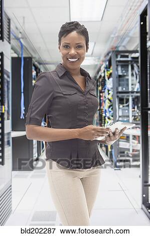 Stock Photo - African American businesswoman in server room. Fotosearch