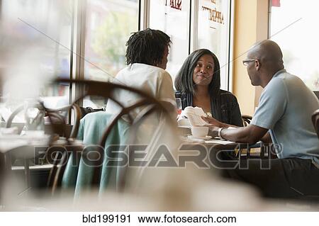 Stock Image - African American co-workers working in restaurant. Fotosearch