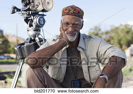 Stock Image - African American director near film camera. Fotosearch