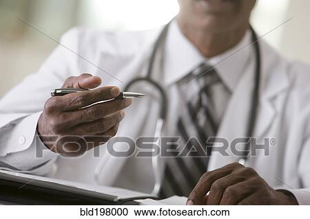 Stock Image - African American doctor writing in medical record. Fotosearch