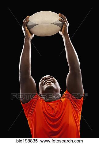 Stock Photography - African American man holding rugby ball. Fotosearch