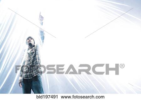 Stock Image - African American man pointing at light spark. Fotosearch