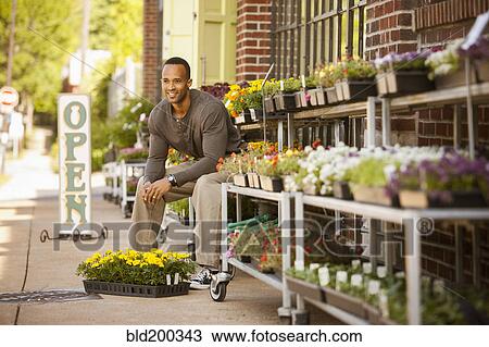 African American man sitting with flowers at flower shop View Large Photo Image Stock Image - African American man sitting with flowers at flower shop. Fotosearch