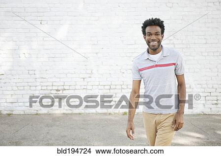 Picture - African American man standing on sidewalk. Fotosearch