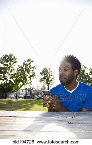 African American man text messaging outdoors View Large Photo Image Stock Photo - African American man text messaging outdoors. Fotosearch