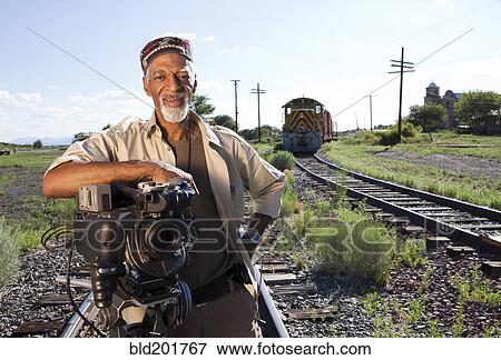 African American man with film camera near railroad tracks View Large Photo Image Stock Photo - African American man with film camera near railroad tracks. Fotosearch