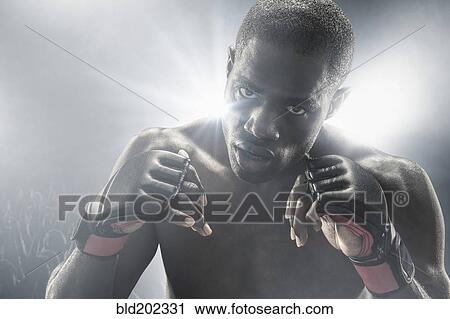 Stock Image - African American MMA boxer with gloves raised. Fotosearch