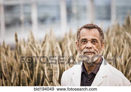 Stock Photo - African American scientist working in greenhouse. Fotosearch