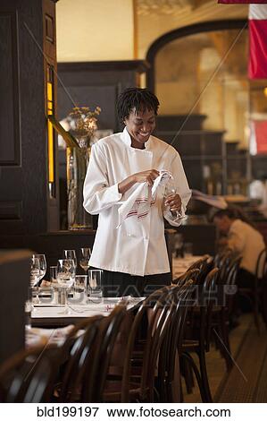 African American waitress checking wine glass in restaurant View Large Photo Image Stock Photo - African American waitress checking wine glass in restaurant. Fotosearch
