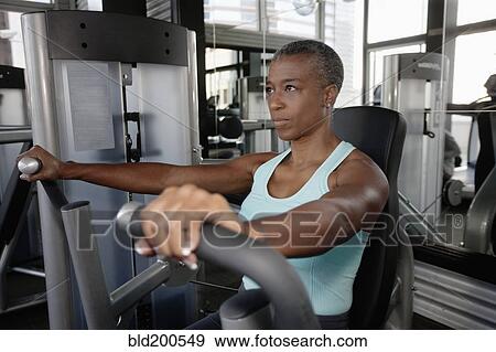 Stock Photo - African American woman exercising in health club. Fotosearch