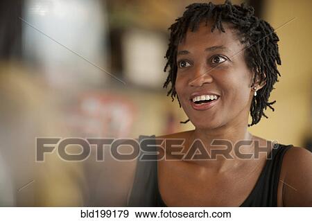 Stock Photo - African American woman having lunch in restaurant. Fotosearch