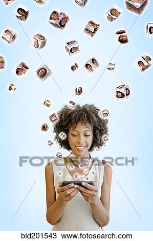 African American woman using cell phone with images floating above View Large Photo Image Stock Image - African American woman using cell phone with images floating above. Fotosearch