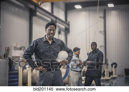 Stock Photography - African American worker standing in factory. Fotosearch