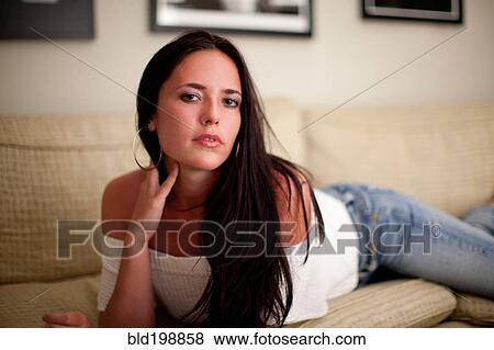 Stock Photo - Alluring Caucasian woman laying on sofa. Fotosearch