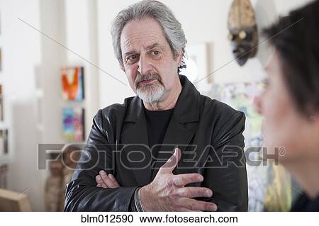 Stock Image - Art gallery curator talking to customer. Fotosearch