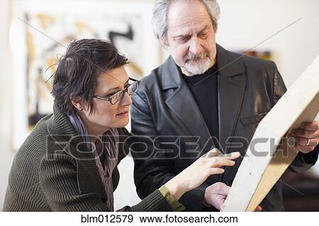 Stock Photo - Art gallery curator talking with customer. Fotosearch