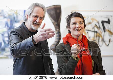 Stock Photograph - Art gallery curator talking with customer. Fotosearch