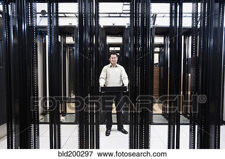Stock Photo - Asian businessman standing in empty server room. Fotosearch