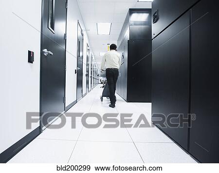 Stock Photo - Asian businessman walking in server room. Fotosearch